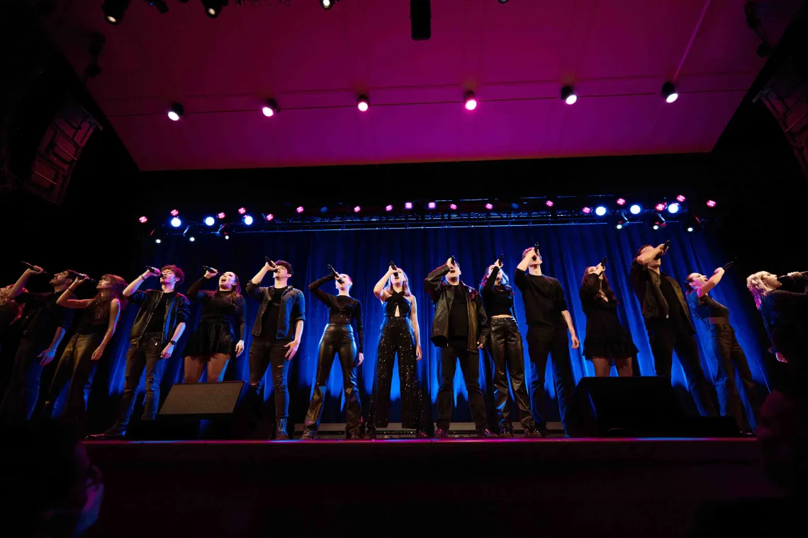 An acapella team performs on stage 