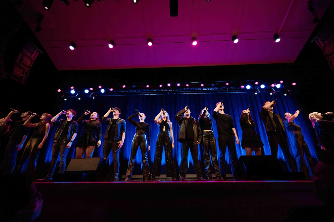 An acapella team performs on stage 