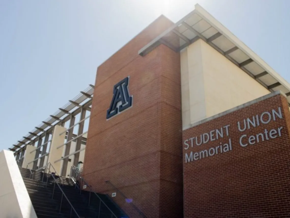 The student union memorial center entrance with the sun beaming in the background