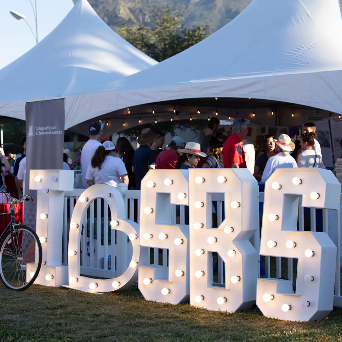 A tent with bright letters and lights titled "I HEART SBS"