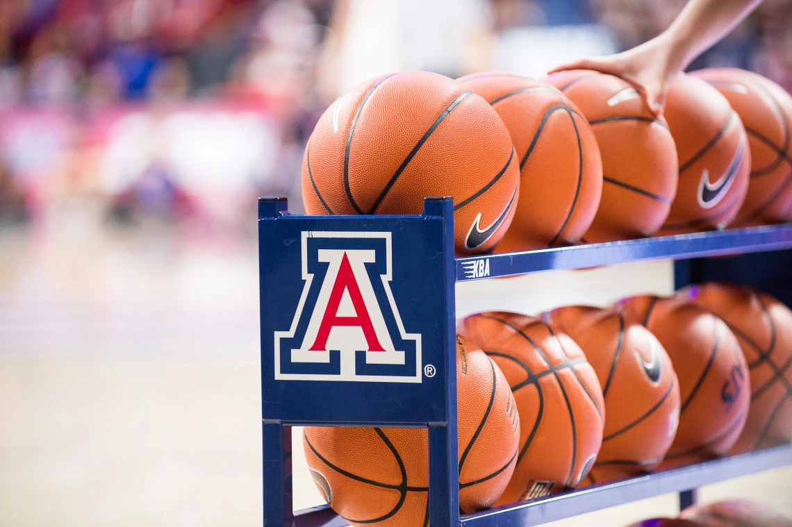 A hand grabbing basketballs from a "Block A" rack 