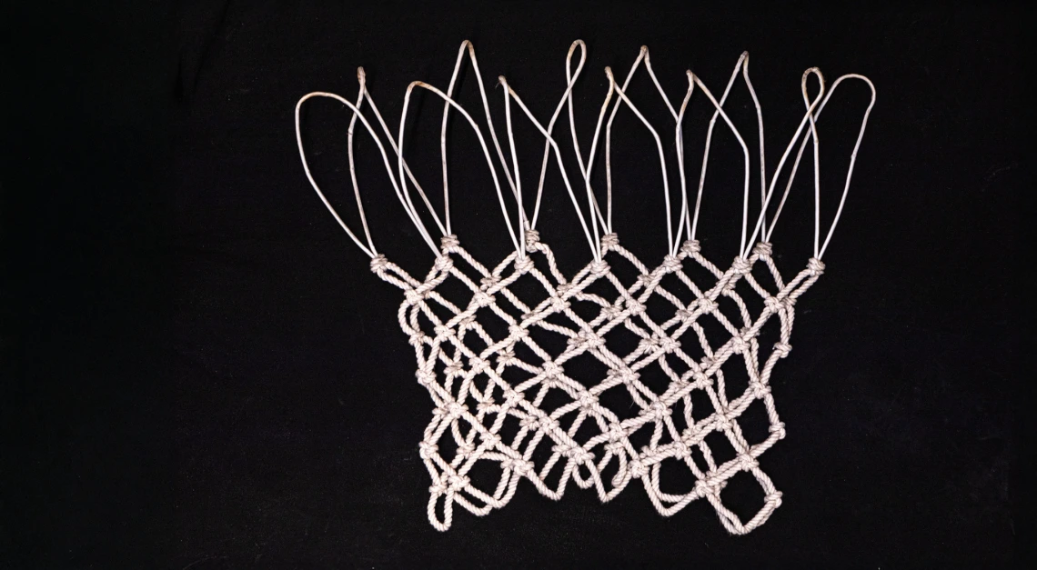 A generated image of a practice basketball net laying flat against a black background.