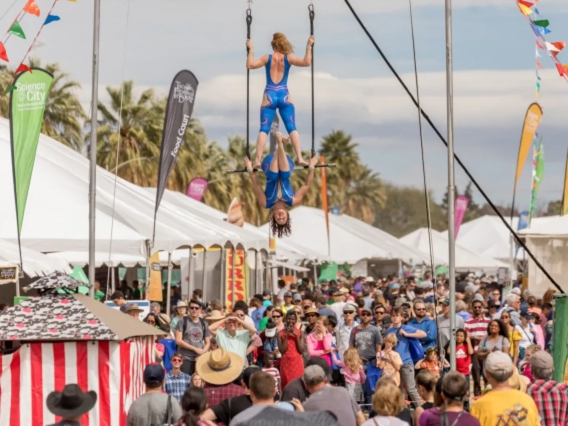 large group of people watching trapeze artists on the university of arizona mall