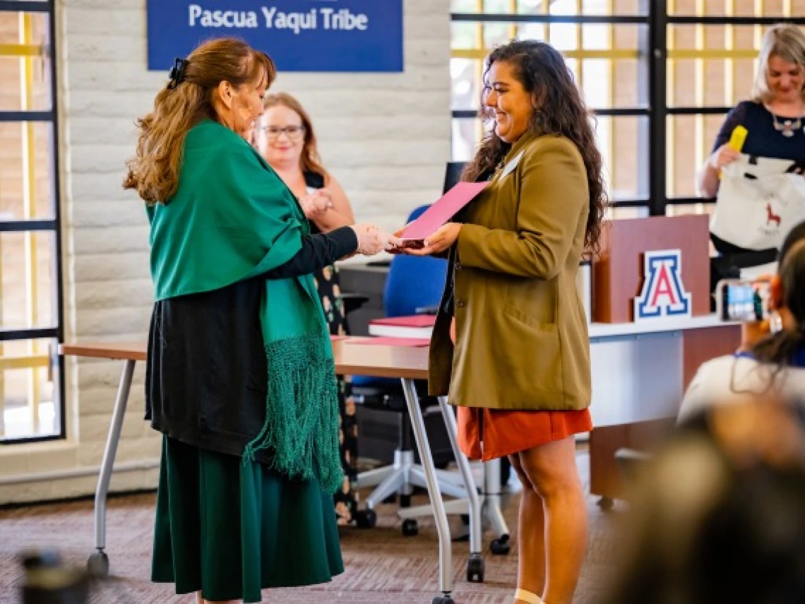 Nicolette Gomez presenting a certificate to Suzie Francisco