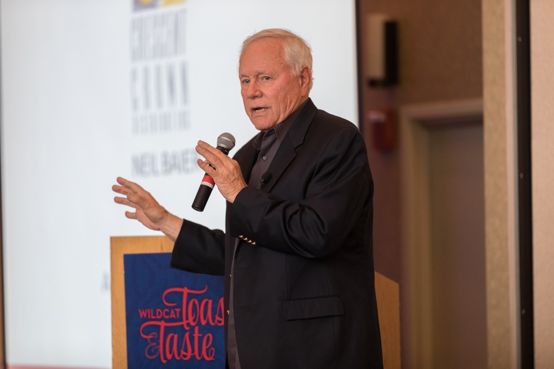 A photograph of Dick Tomey, speaking into a microphone