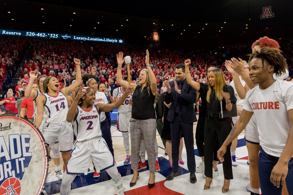 A photograph of Adia Barnes celebrating with the women's basketball team