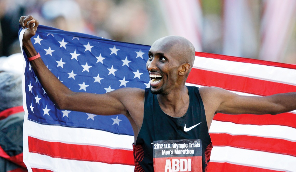 A photograph of Abdi Abdirahman holding the American flag at the 2012 U.S. Olympic Trials