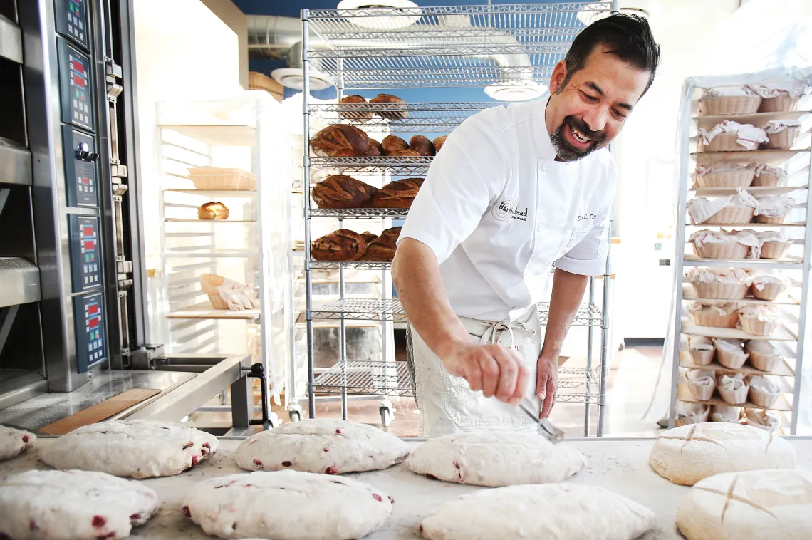 A photograph of Don Guerra rolling out dough to create bread