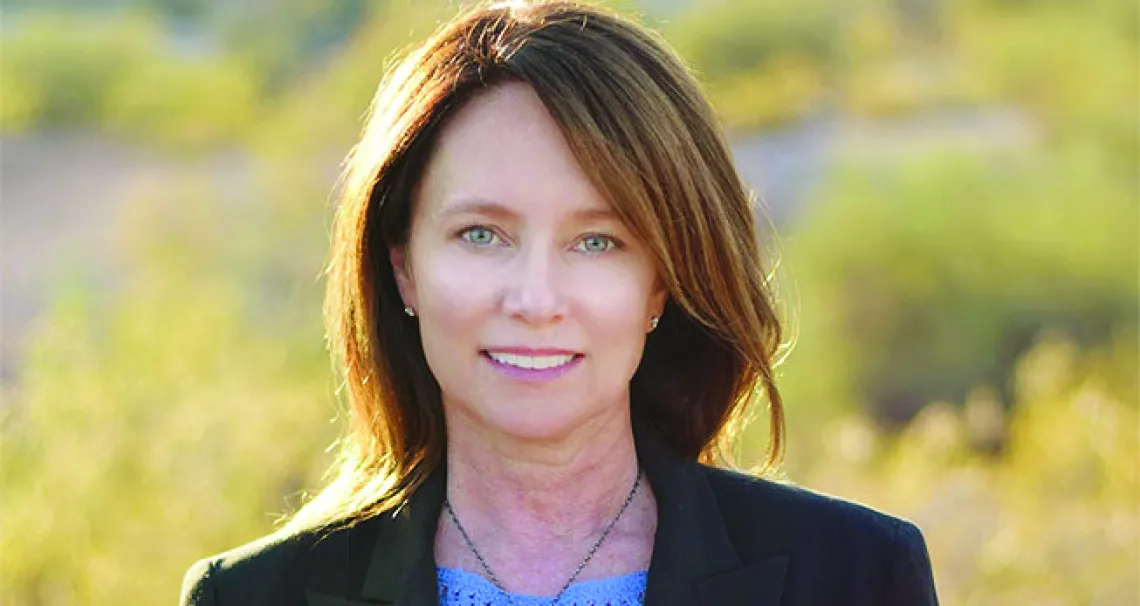 A headshot of Brenda Burman standing in a yellow field