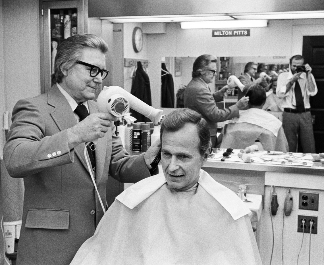 A photograph of CIA Director George H.W. Bush getting his hair blow dried by White House barber Milton Pitts