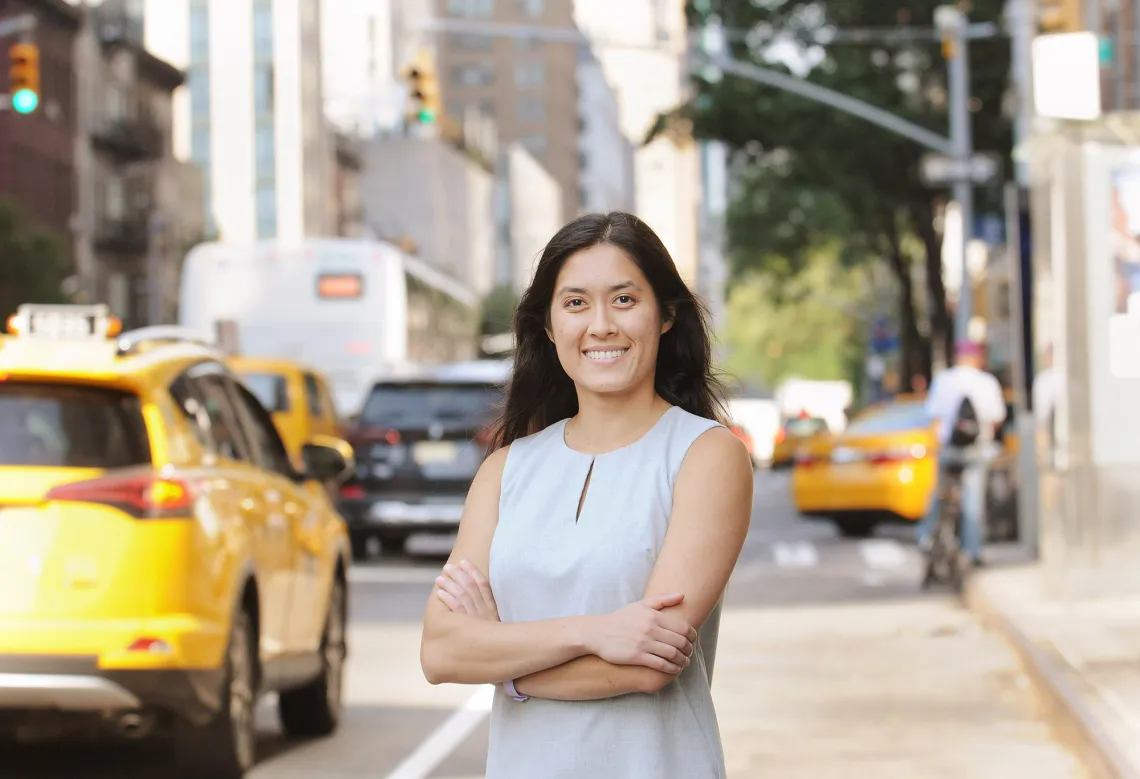 A photograph of Chardee Allee, with her arms crossed and smiling