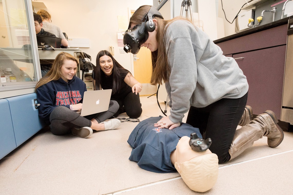 A photograph of UA engineering students using their virtual reality system for CPR training