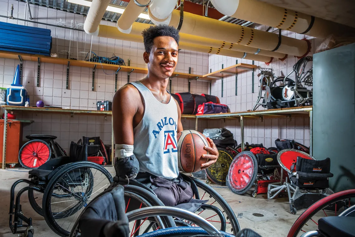 A photograph of John Brewer holding a basketball