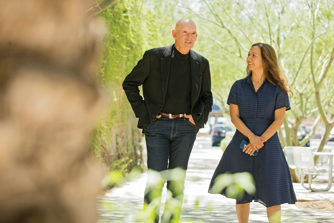 A photograph of Howard Glasser and Velia Nuño walking across campus