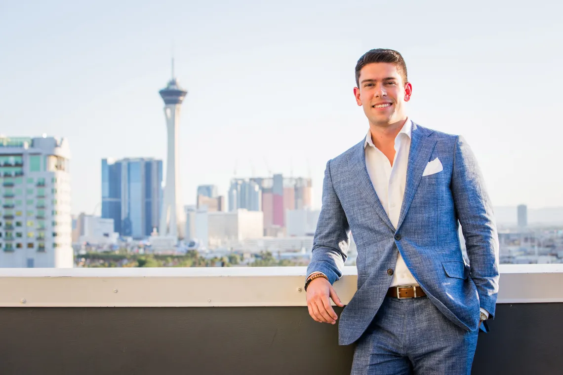 A photograph of James Losole standing and smiling