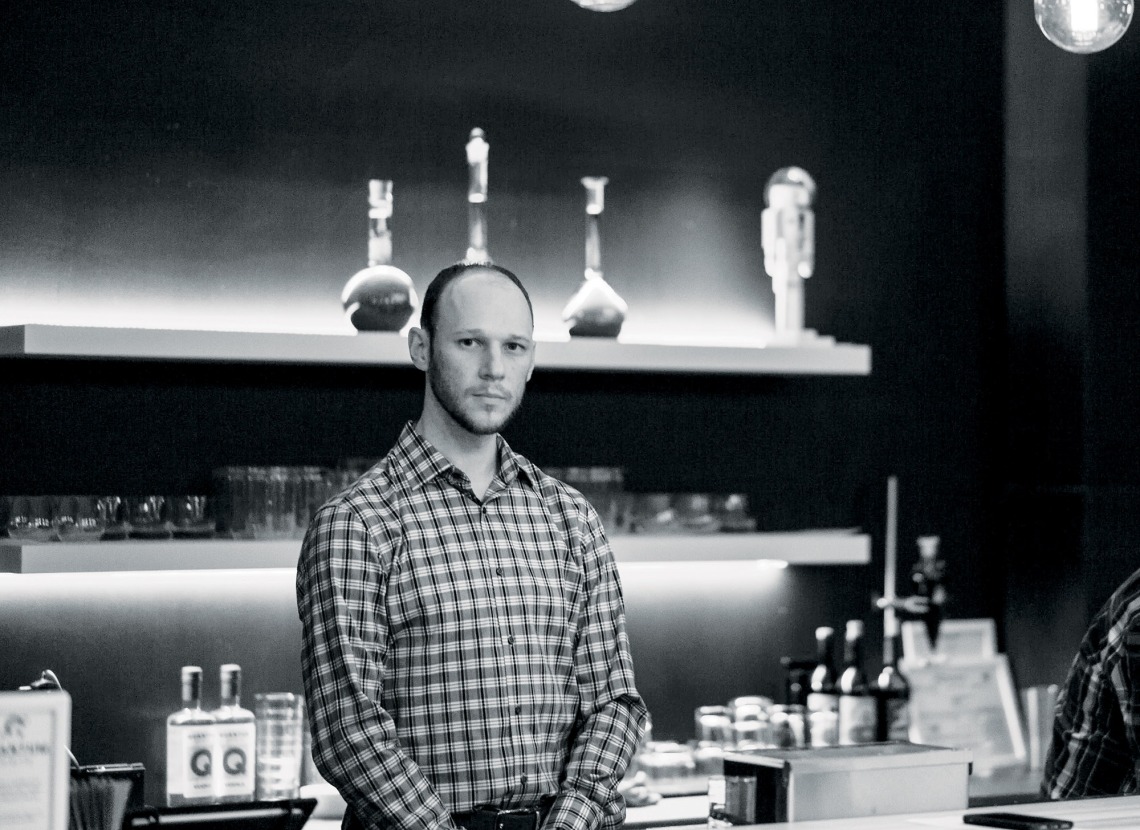 A photograph of Ryan standing behind the bar