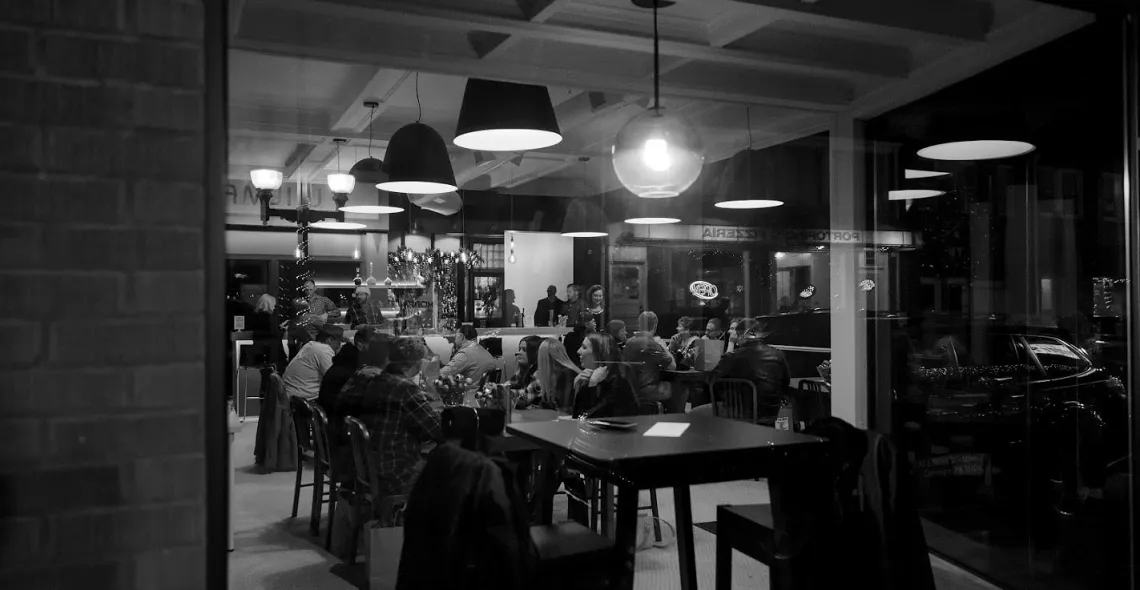 A black and white shot of a dining area lined with lamps