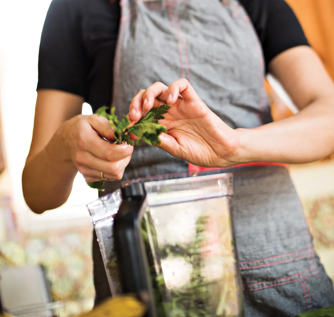 A photograph of Megan creating a dish in a blender