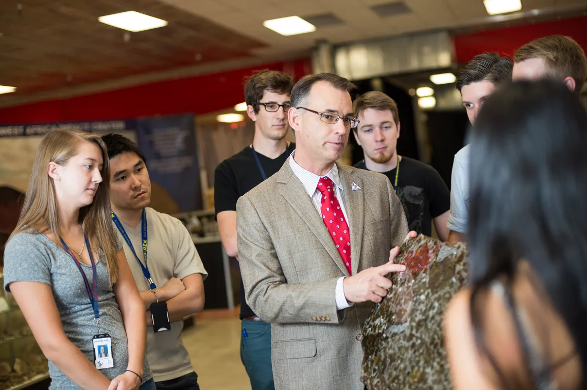 A photograph of Dante Lauretta speaking to students 