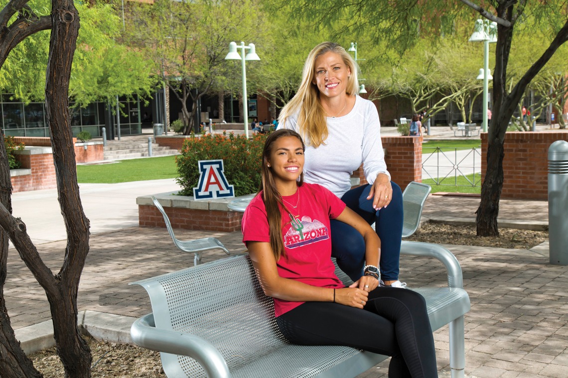 A photograph of Mia and Jeannine Mason sitting on a park bench posing for the camera