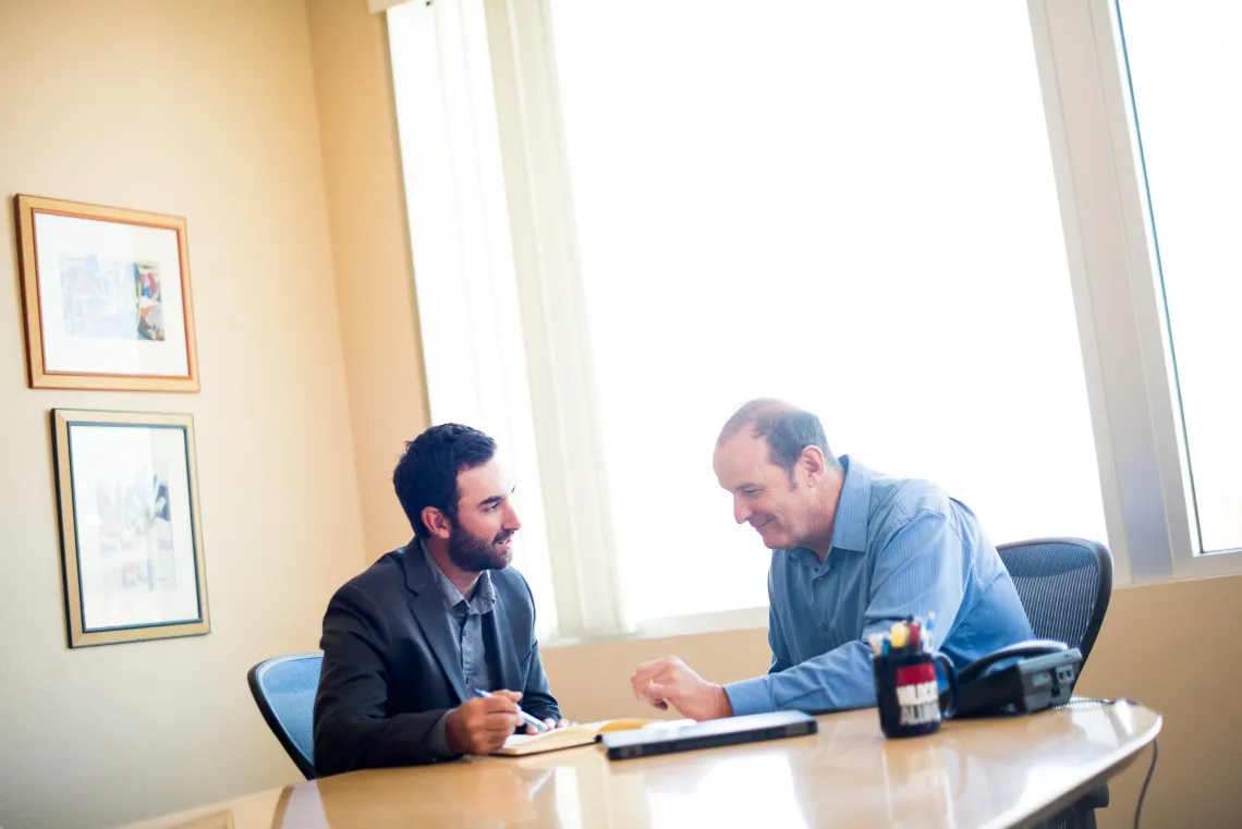 A photograph of a mentor speaking to a mentee