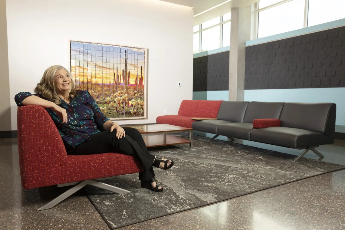 A photograph of a woman lounging on a sofa, in the John and Helen Murphey Living Room