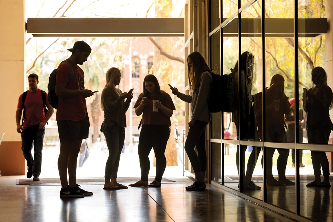 A crowd of students in the Student Union, all looking at their phone