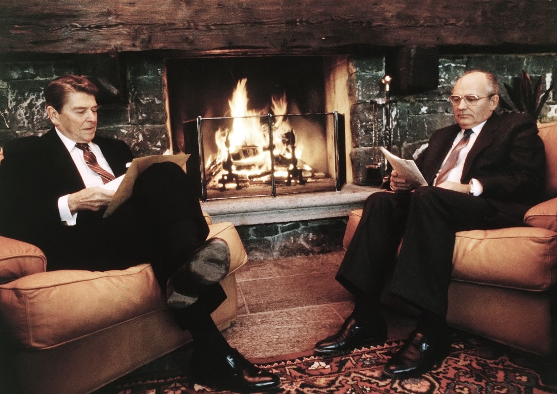 A photograph of President Ronald Reagan and Soviet General Secretary Mikhail Gorbachev sitting on a couch looking at paper