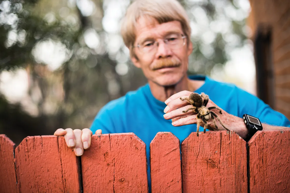 A photograph of Justin Schmidt holding a tarantula