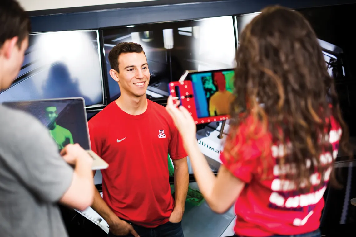 A photograph of three students using technology from the Main Library to film a student