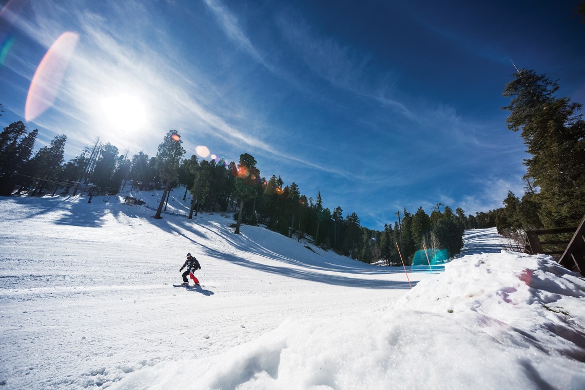 A photograph of a skier gliding down a snowy slope