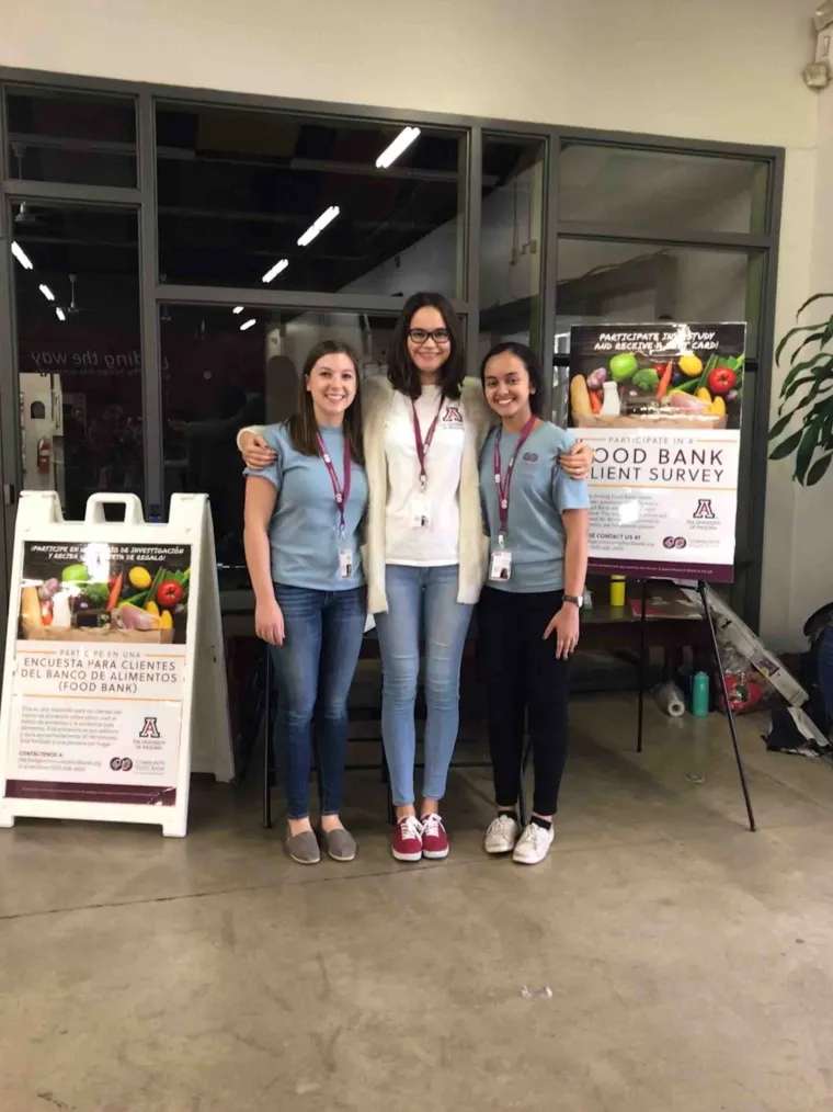 Students pose and smile at the community food bank