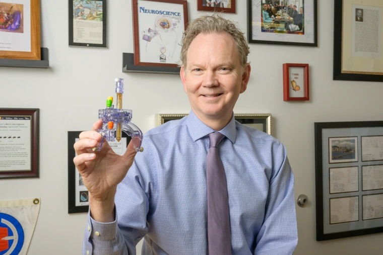 Dr. Larson holding up his gizmo