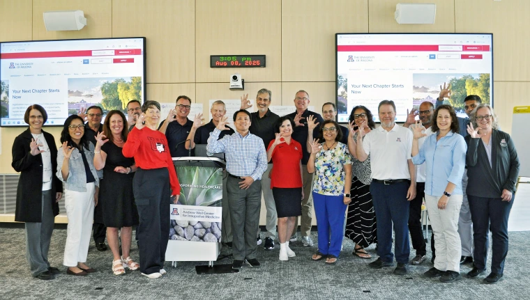A photograph of university deans and Provost Prelock smiling and holding up the Wildcat hand gesture.