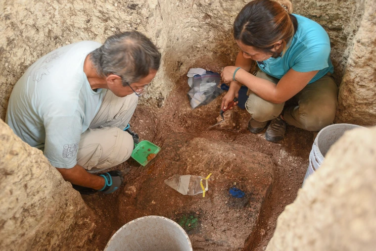 U of A archaeologists excavating a cache of ceremonial artifacts.