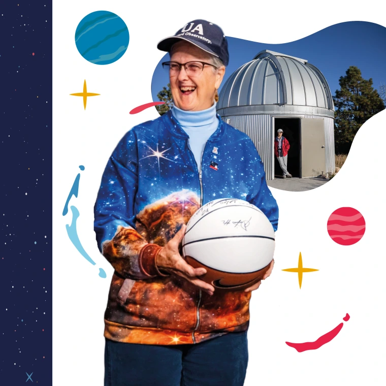 A person wearing a University of Arizona cap and a space-themed jacket holds a signed basketball. The jacket features images of stars, nebulae and galaxies.