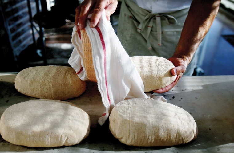 A photograph of Don taking out the raised loaf from the terrycloth