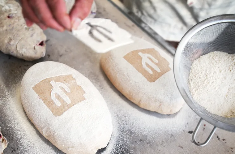 A photograph of Don "stamping" his trademark cactus with flour onto the loaves 