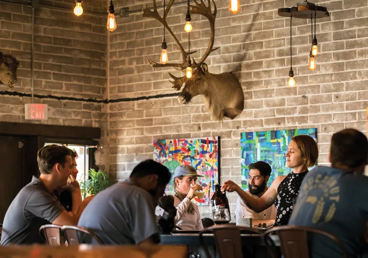 A photograph of a group of younger individuals sitting around in a quirky space