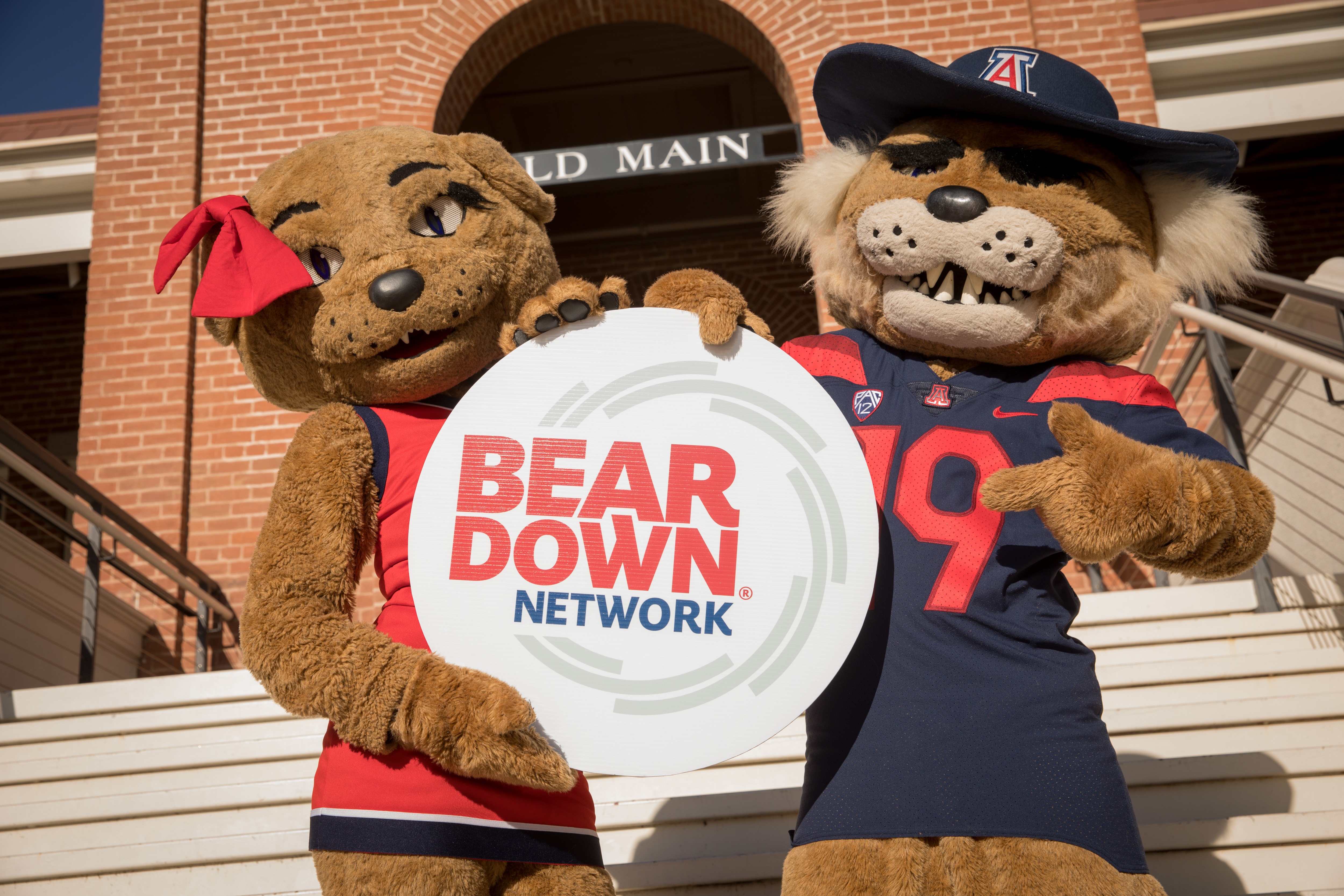 Wilma and Wilbur mascots holding Bear Down Network sign