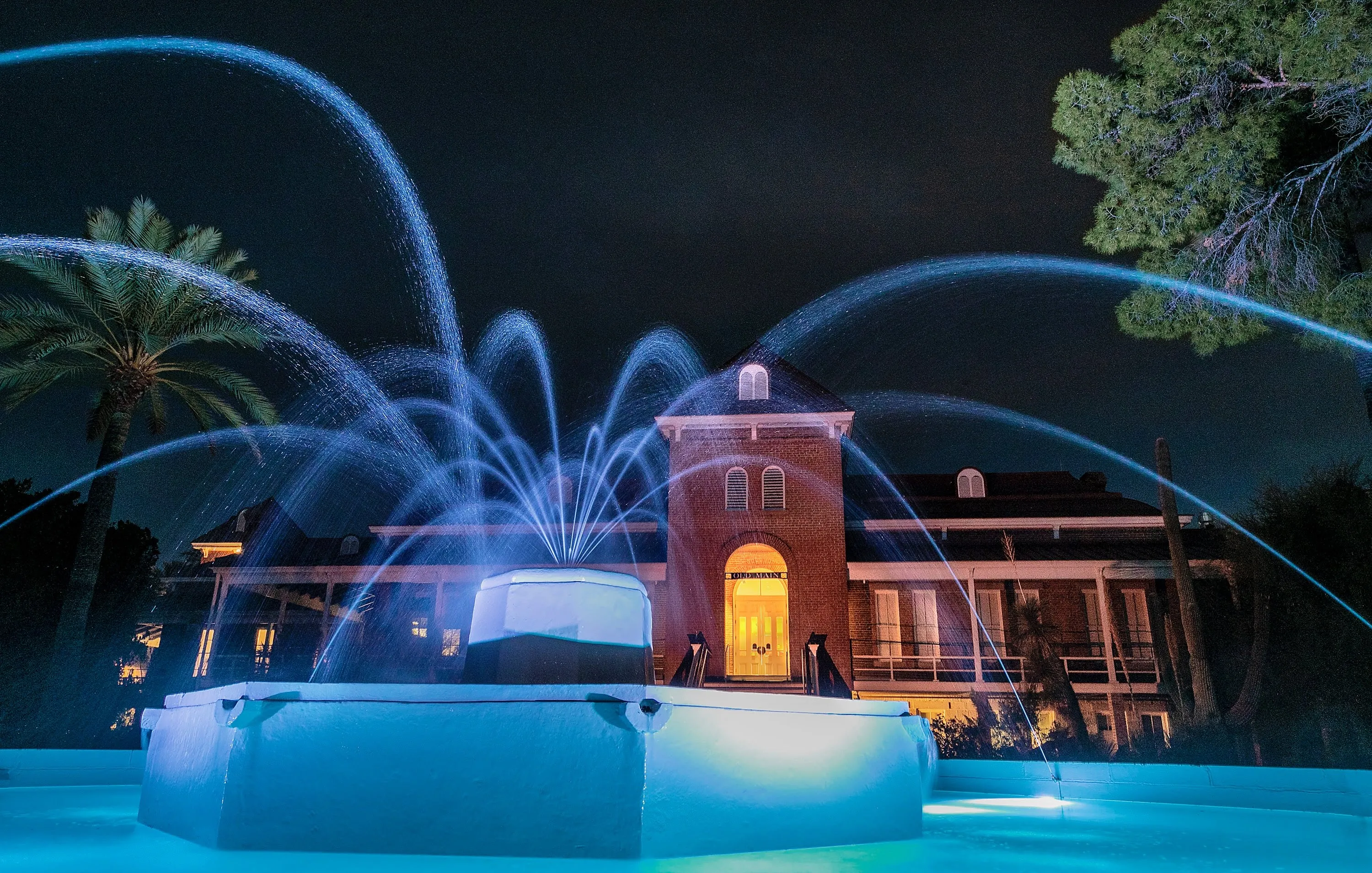 Old Main with fountain in foreground, at night with dramatic lights