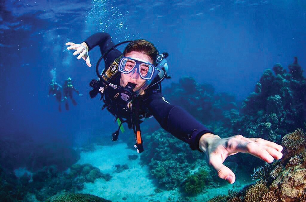 A photograph of Canyon Smith scuba diving in the Great Barrier Reef