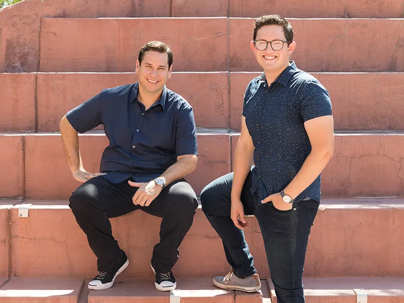 A photograph of Carlos Chavez and Cisco Aguilar sitting outside the Student Union Memorial Center