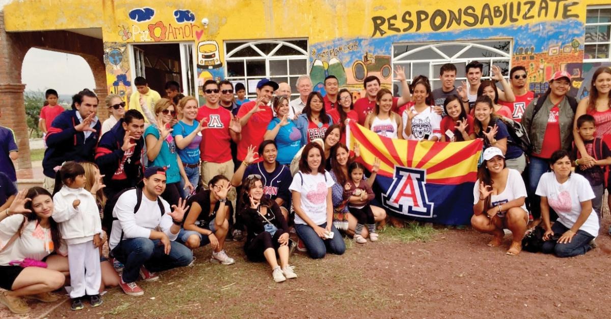 Maria Vasquez and a group of families posing with an Arizona flag