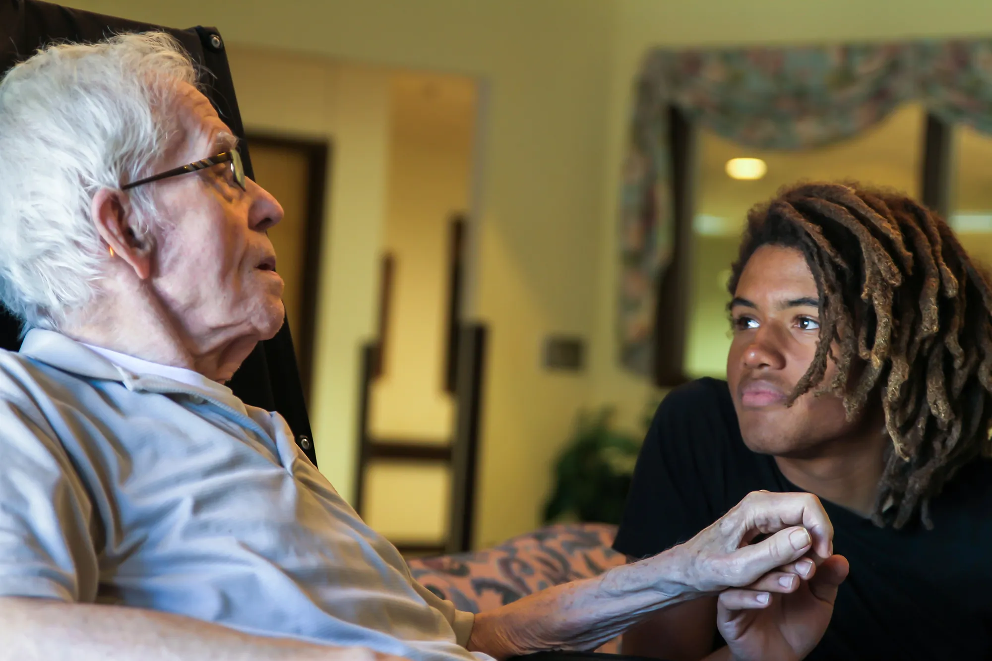 Young man speaks with elderly man