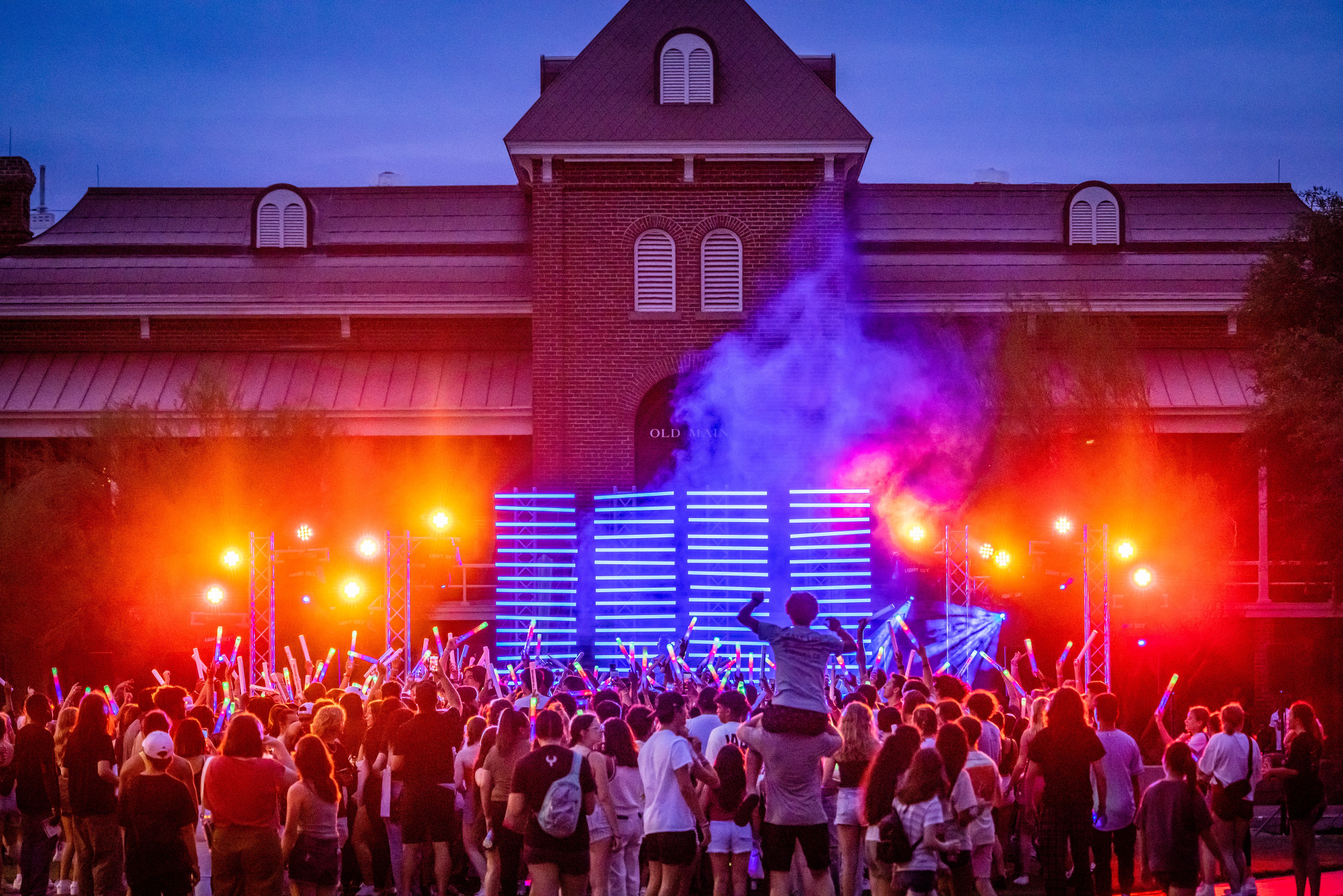 Students holding glowsticks gather outside Old Main during Destination Arizona, a new orientation program for first-year Wildcats. 