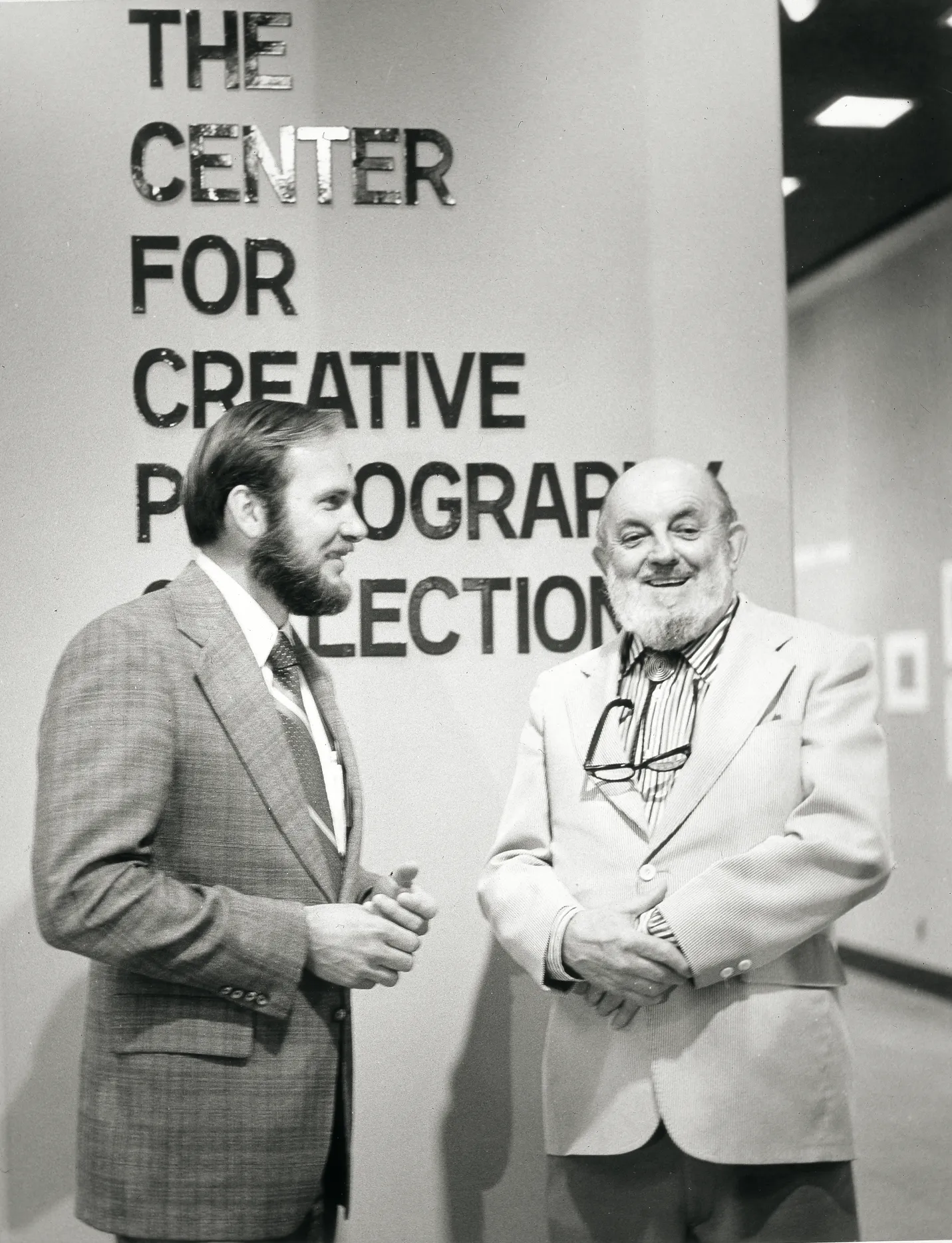 Two men smiling in front of The Center for Creative Photography entrance