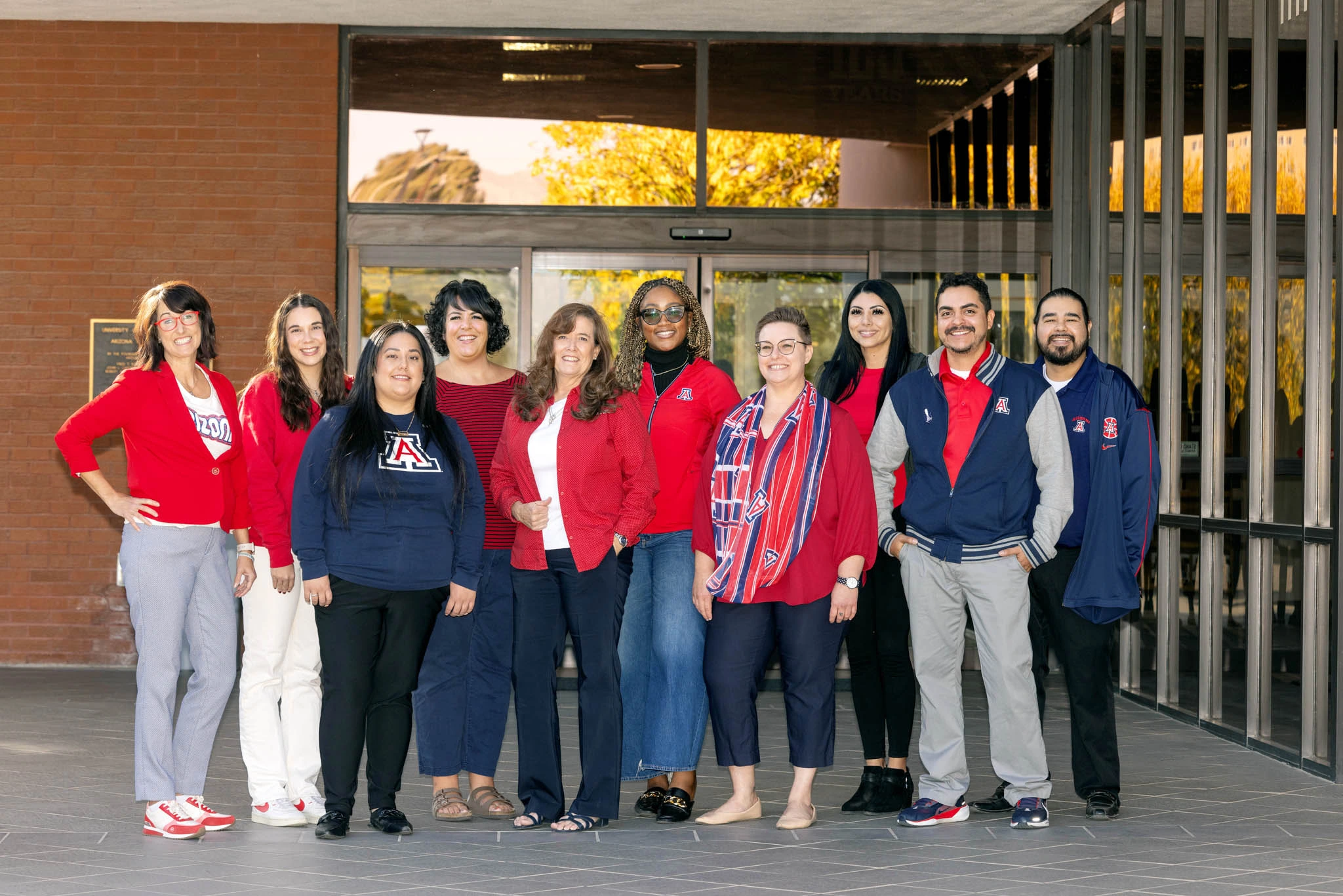 The Alumni Engagement Team standing and smiling in front of the Swede building