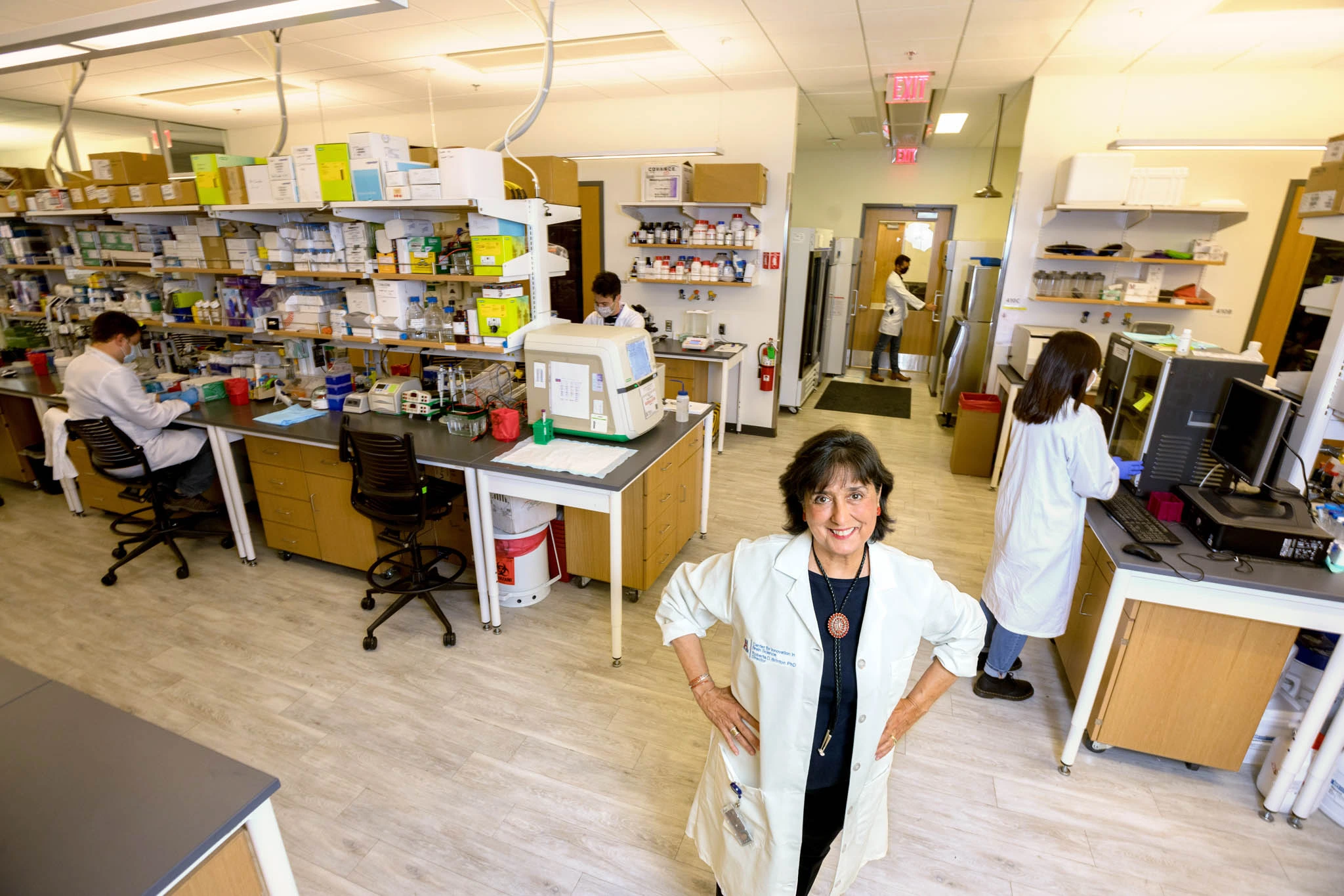 Roberta smiling and looking up while her lab works in the background