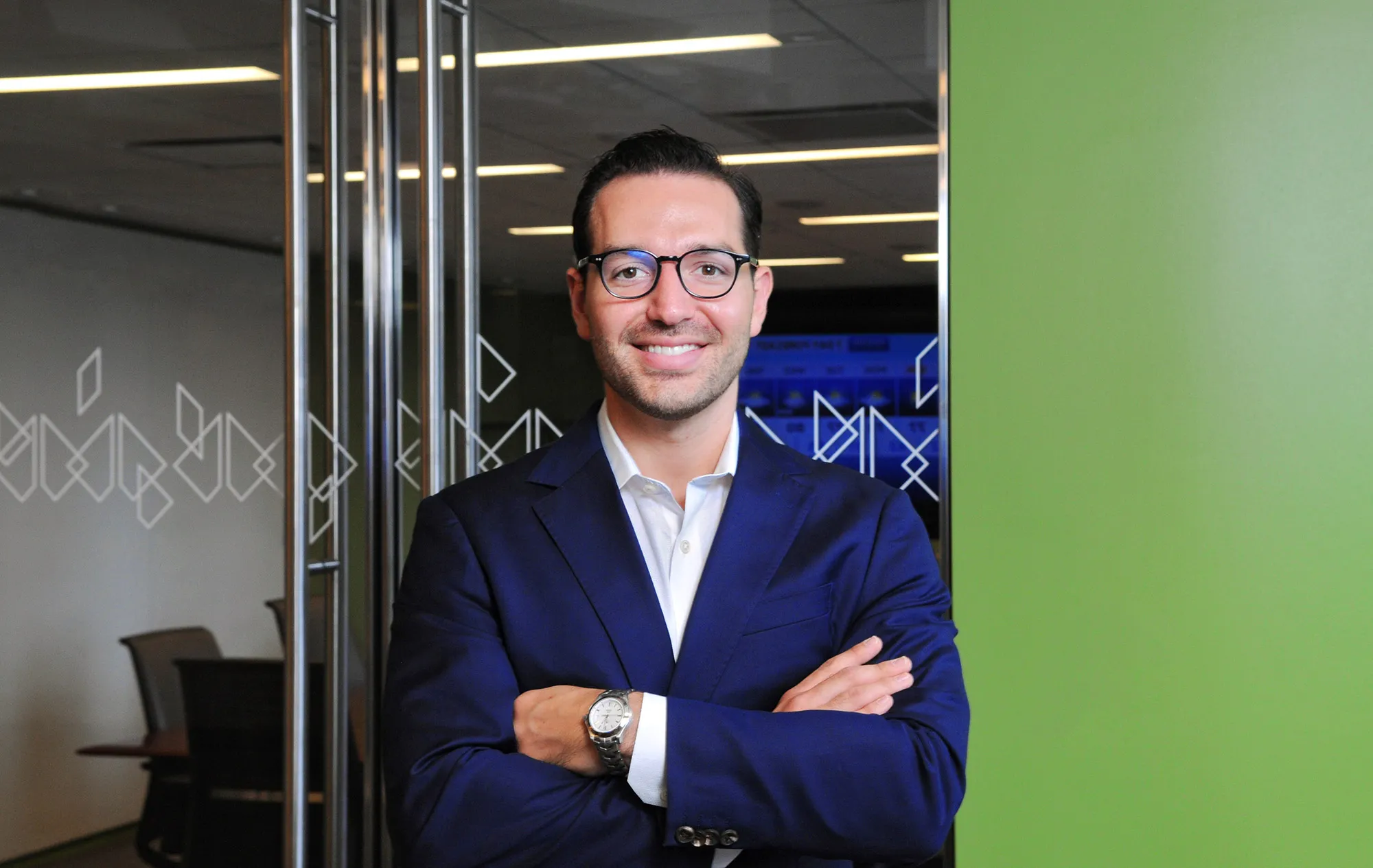 A photograph of Manuel Felix smiling with his arms crossed